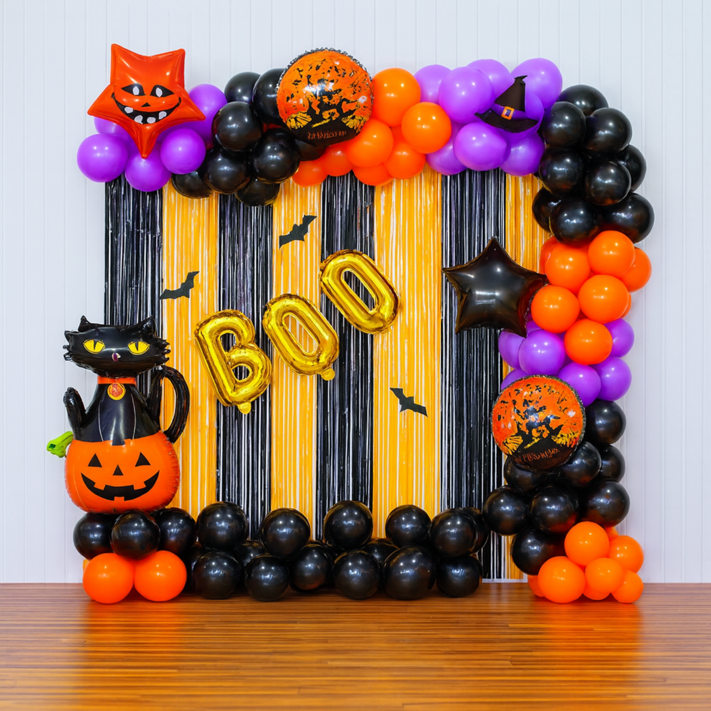 Halloween “BOO” balloon backdrop with black cat, pumpkin balloons, and orange, black, and purple balloon arch.