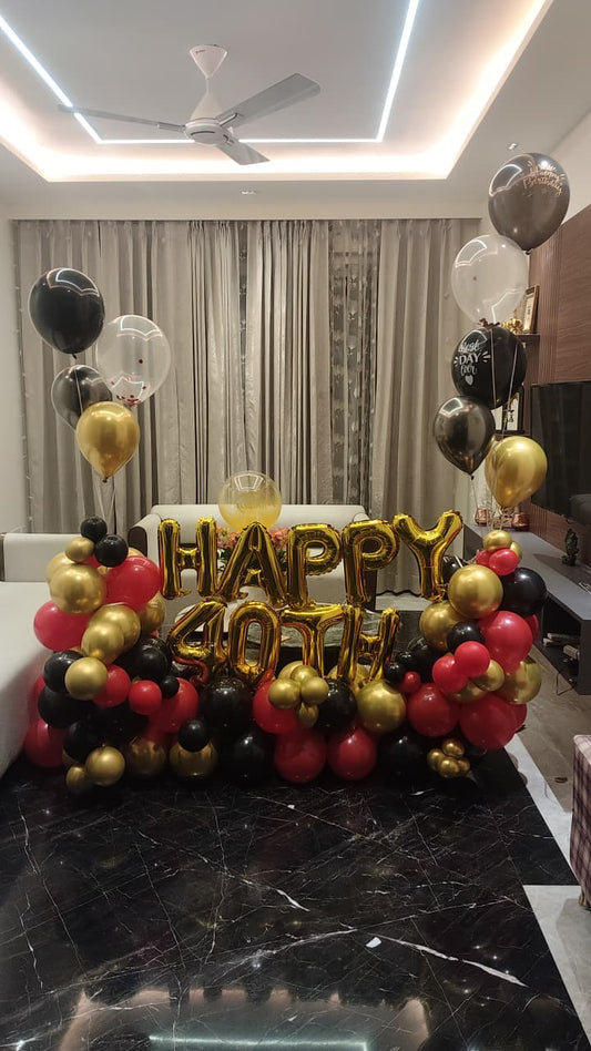40th birthday balloon decoration at home with gold foil 'HAPPY 40TH' balloons, red black and gold balloon clusters and floating balloons