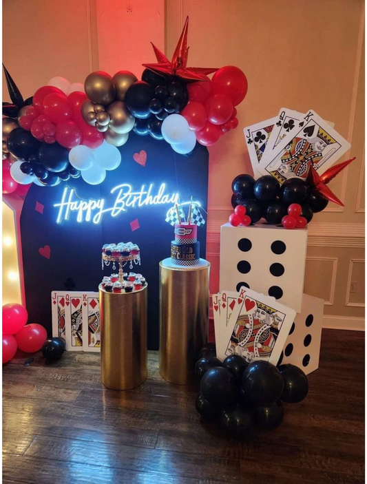 Casino theme birthday backdrop with red black gold balloons, playing cards, dice props, and neon Happy Birthday sign — perfect for poker or Vegas-style party decoration.
