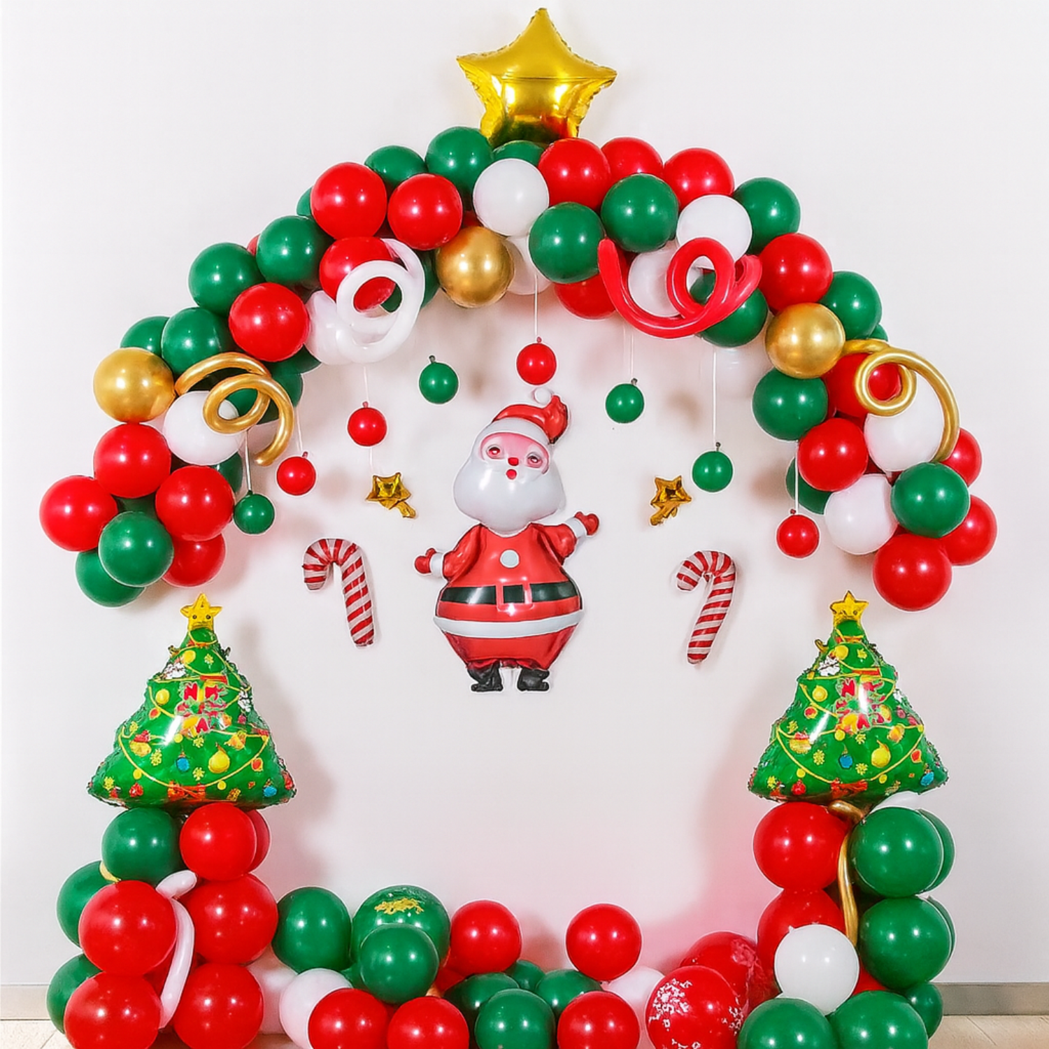 Christmas balloon decoration with Santa centerpiece, red-green-gold balloon arch, candy canes, and Christmas tree balloons.