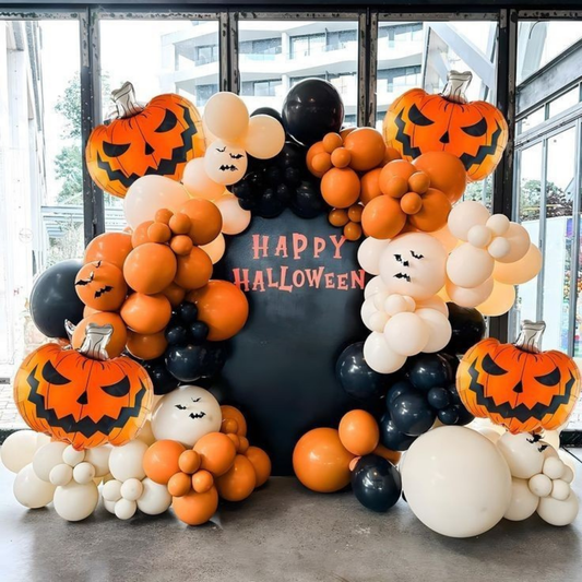 Halloween balloon decoration with pumpkin balloons, ghost faces, and black-orange balloon arch backdrop.