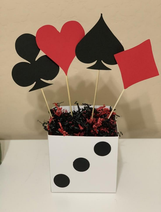Casino theme table centerpiece with red and black playing card symbols — heart, spade, club, and diamond — arranged in a white box with black dots.