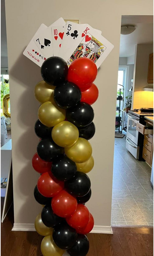 Casino theme wall decoration with hanging card suits including hearts, spades, clubs, and diamonds for poker night or Vegas party backdrop.