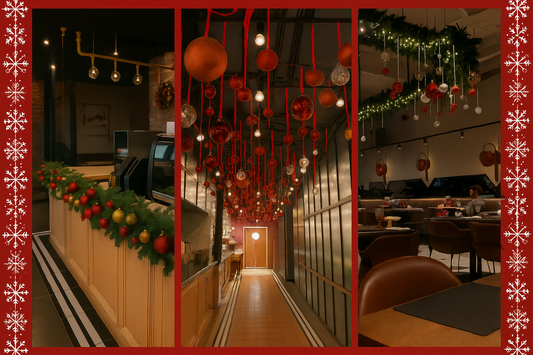 Christmas restaurant decor setup featuring garland-covered counter, hanging red and gold ornaments, and ceiling greenery with fairy lights by Renowned Events