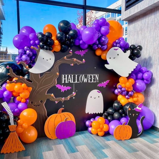 Halloween entrance setup with scary pumpkin cutouts, Enter at Your Own Risk sign, and black orange balloon pillars for party decoration.
