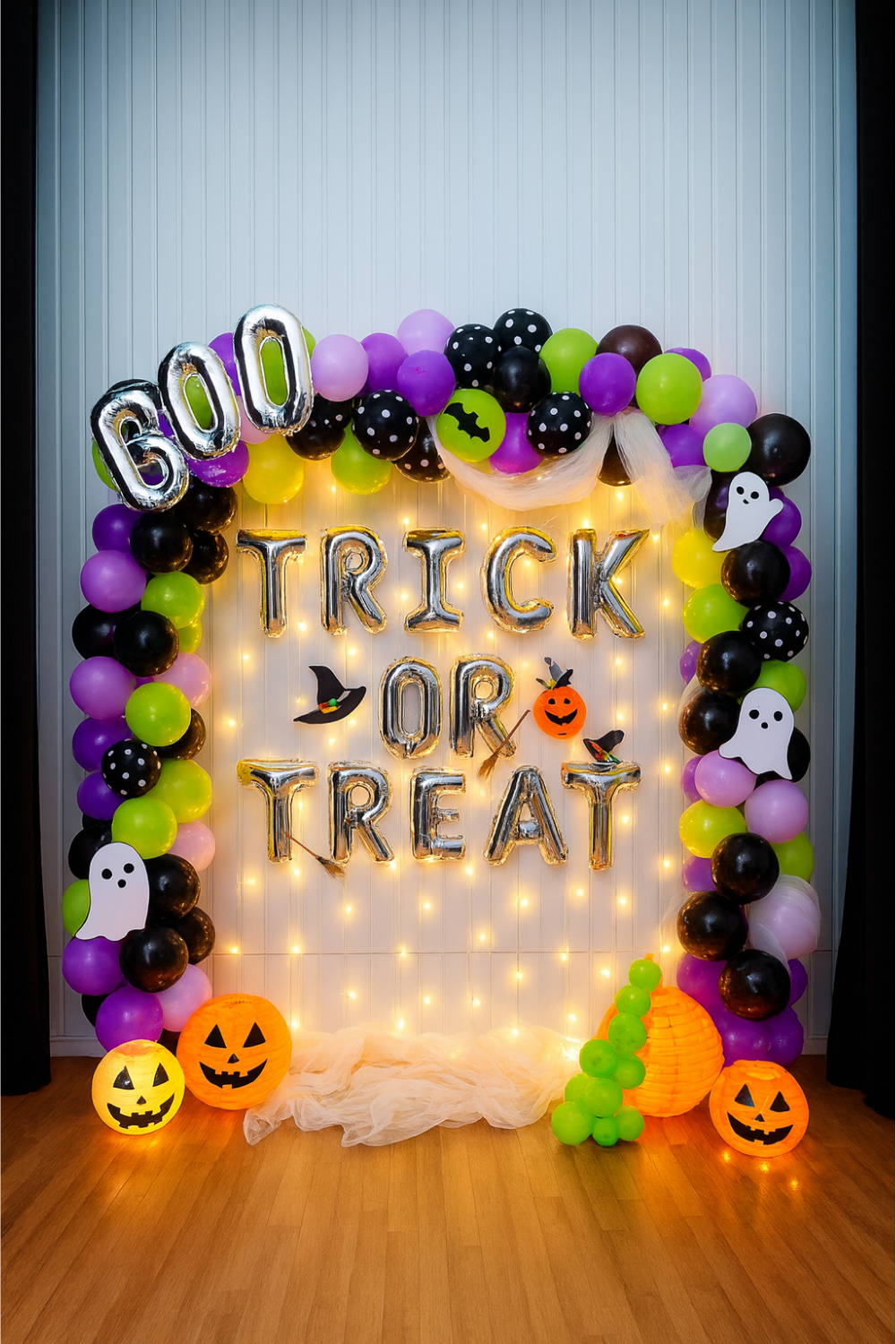 Halloween “Trick or Treat” balloon decoration backdrop with fairy lights, pumpkins, ghosts, and colorful balloons.